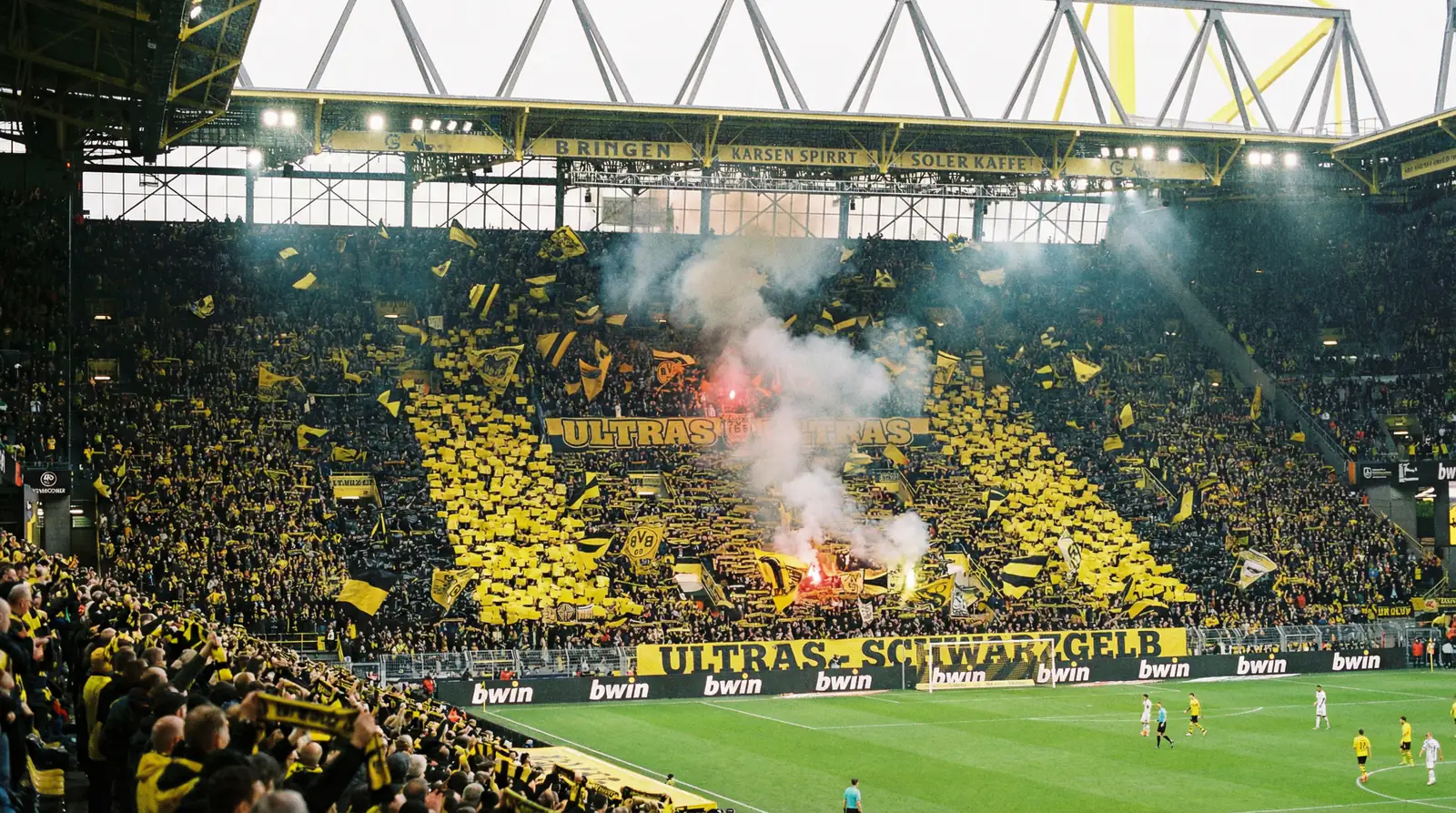 Grada sur del Signal Iduna Park repleta de aficionados con banderas amarillas y negras durante un partido de Bundesliga