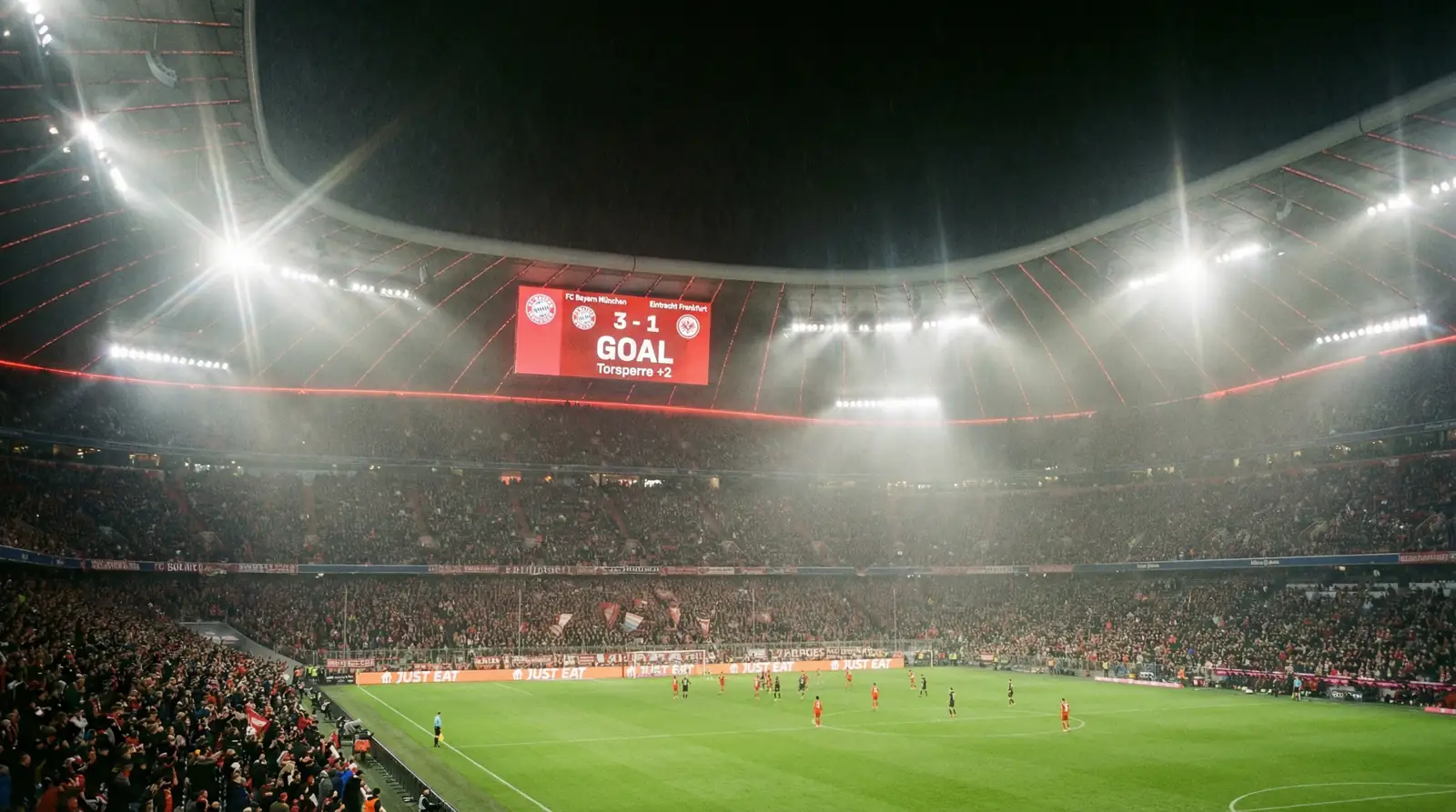Marcador electrónico de un estadio de fútbol alemán mostrando un resultado con diferencia de goles durante un partido nocturno